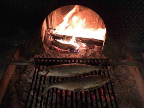 Coregone cooking over the hot coals