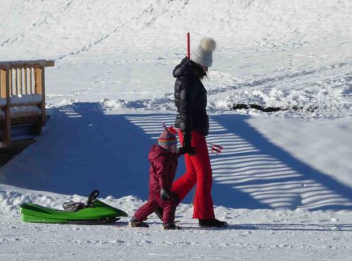 They start them early here; this little one was an expert striding along on her tiny red skies