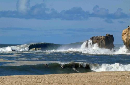 On this day we were told the surf was flat, but it didn't look that way; certainly there was enough of a wave to give these few surfers (in the foreground) a reasonable ride