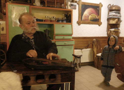 Ivan's grandson listens as he plays the alpine zither 