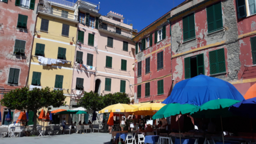 The brightly-coloured umbrellas contrast with the faded beauty of the houses