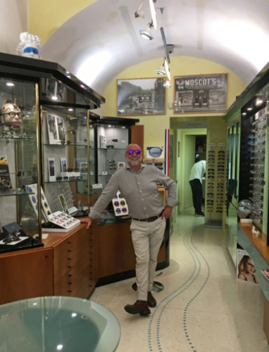 Greg trying a few new styles in Elio's optometry shop in the main street; these narrow, high-ceilinged shops were once the palaces' stables 